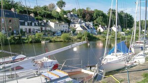 Un port de plaisance où sont amarrés des bateaux, entouré de maisons et de verdure.