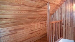Un intérieur en bois avec un plafond en pente et une balustrade en bois.