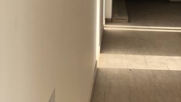 A hallway with a wooden floor and white walls.