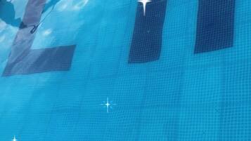 A pool with clear blue water and the letters "LH" visible on the surface.