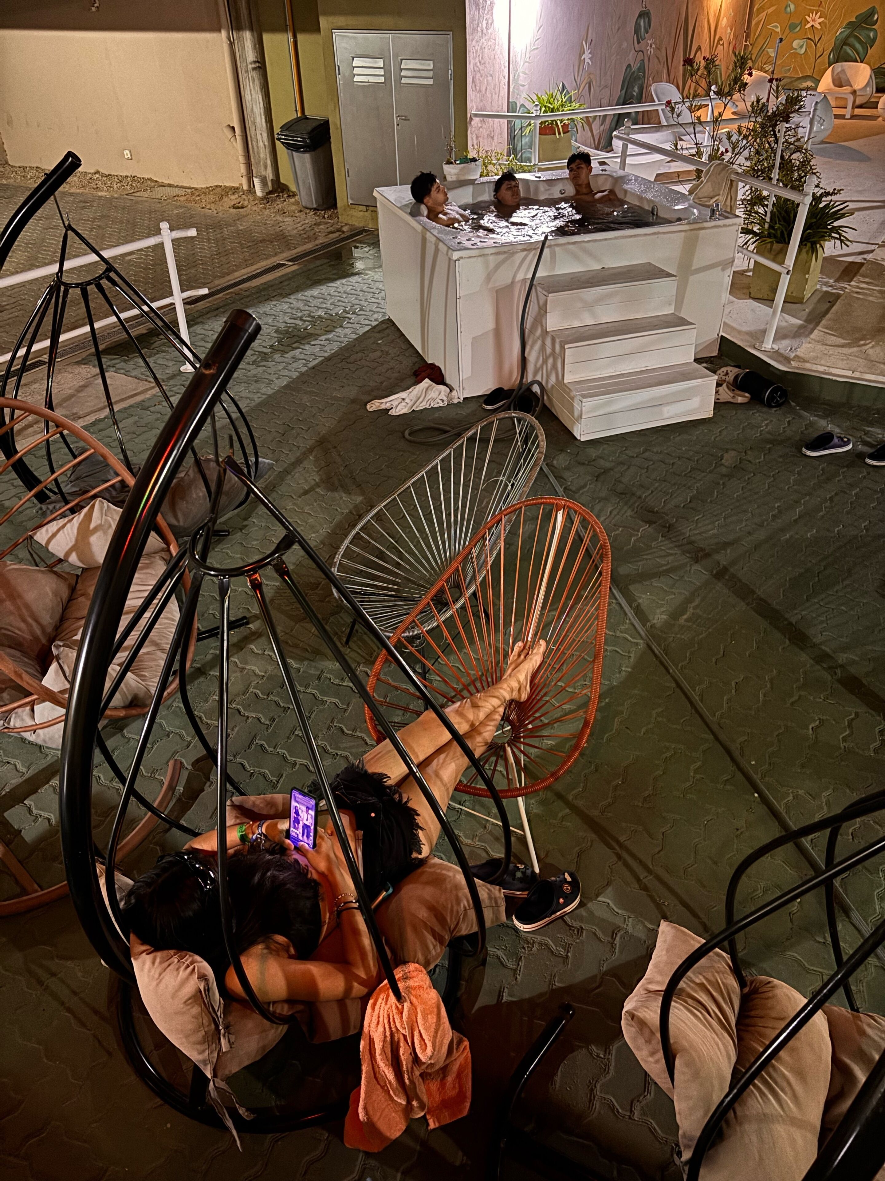 Une pièce comprenant une table de billard, un coin bar et un espace détente avec des fauteuils.