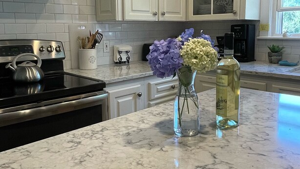 A kitchen with white cabinets, a stainless steel stove, and a marble countertop. - Perfect Maine Getaway – Walk to Downtown, Cozy for All - Flexible Cancellation. (Kennebunk)