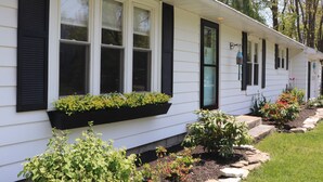 A row of white houses with black shutters and flower boxes on the windowsills. - Perfect Maine Getaway – Walk to Downtown, Cozy for All - Flexible Cancellation. (Kennebunk)