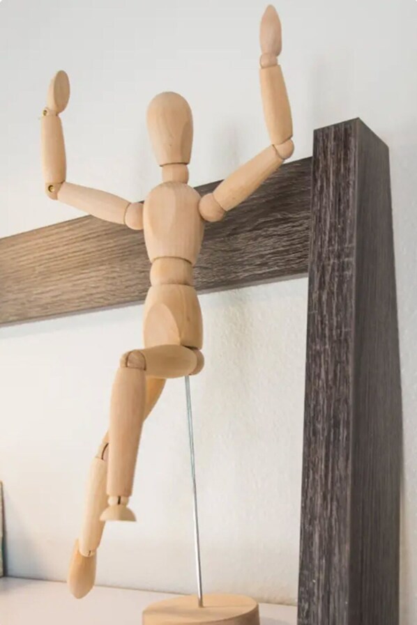 Un maniquí de madera sobre un atril.