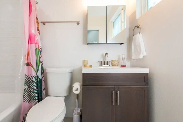 Un baño con inodoro, lavamanos y espejo.
