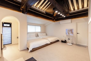 A bedroom with a large bed, a TV, and a window. - Hwarangroo (Gyeongju)
