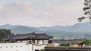 A traditional building with a white exterior and tiled roof, surrounded by a well-maintained lawn and a stone pathway. - Hwarangroo (Gyeongju)