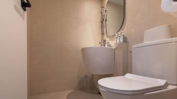A bathroom with a toilet, sink, and shower.
