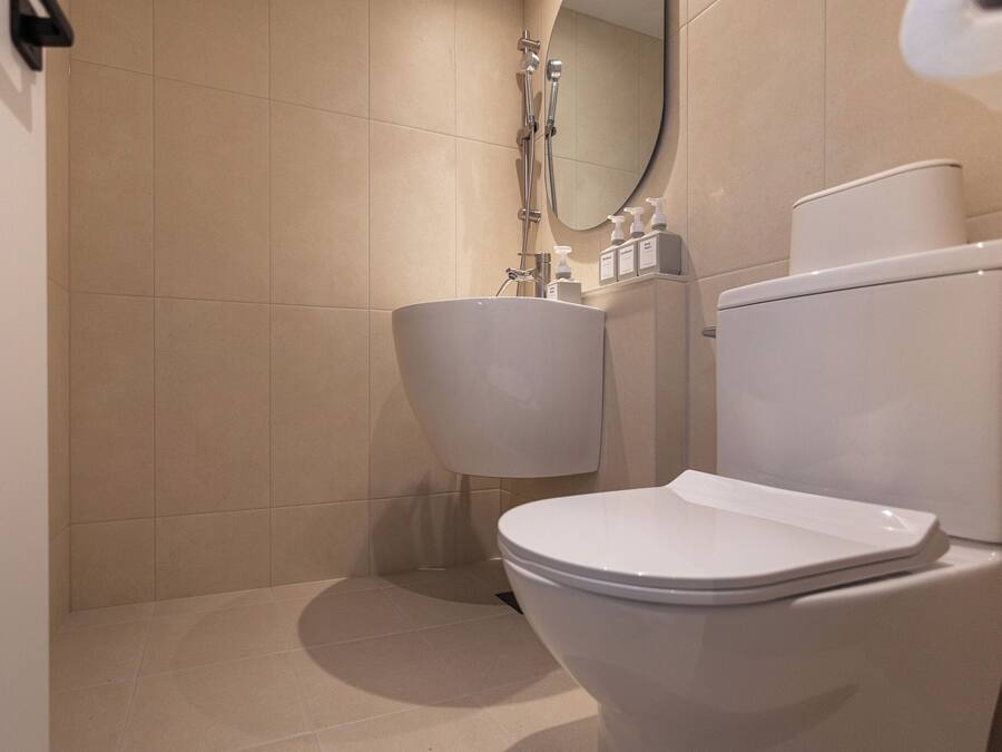 A bathroom with a toilet, sink, and shower.