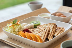 Bandeja de desayuno con tostadas, fruta y ensalada.