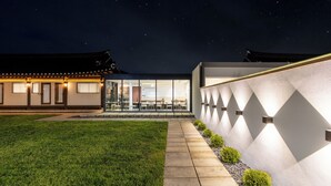 A modern building with a traditional architectural style, a well-maintained lawn, and a clear night sky. - Hwarangroo (Gyeongju)