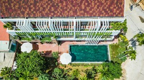 An aerial view of a building with a swimming pool, surrounded by greenery and a white pergola structure. - Opal Boutique Villa (Da Nang)