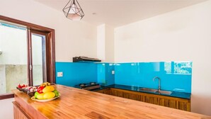 Eine moderne Küche mit einer Holzarbeitsplatte, einer blauen Spritzschutzwand und einem Fenster mit Ausblick.