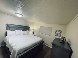 A bedroom with a bed, nightstand, lamp, window, and dresser. - Beautiful 3 bedroom/2 bath + bonus room!  (Keizer)