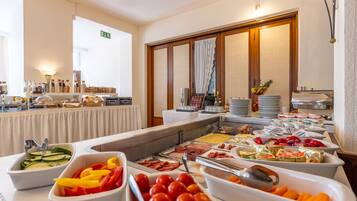 A buffet with various food items including fruits, vegetables, and meats.