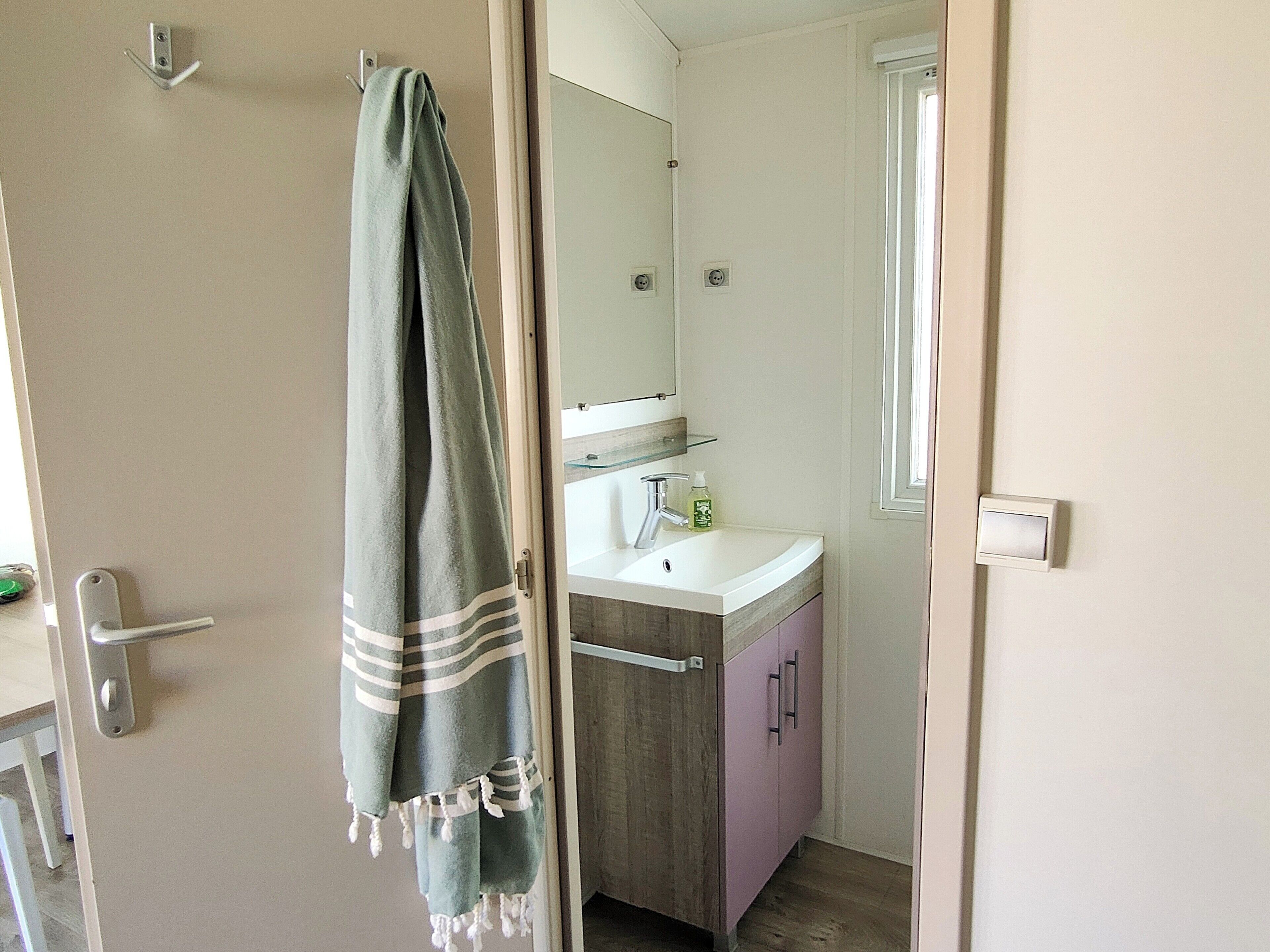 Ein Badezimmer mit Waschbecken, Spiegel und Schrank.