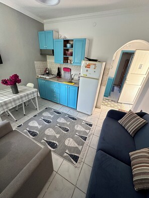 Full-sized fridge, stovetop, electric kettle, cookware/dishes/utensils