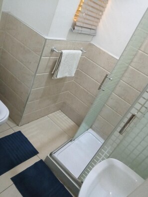 A bathroom with a shower, a toilet, and a bathtub. - The Dernier (Lagos)