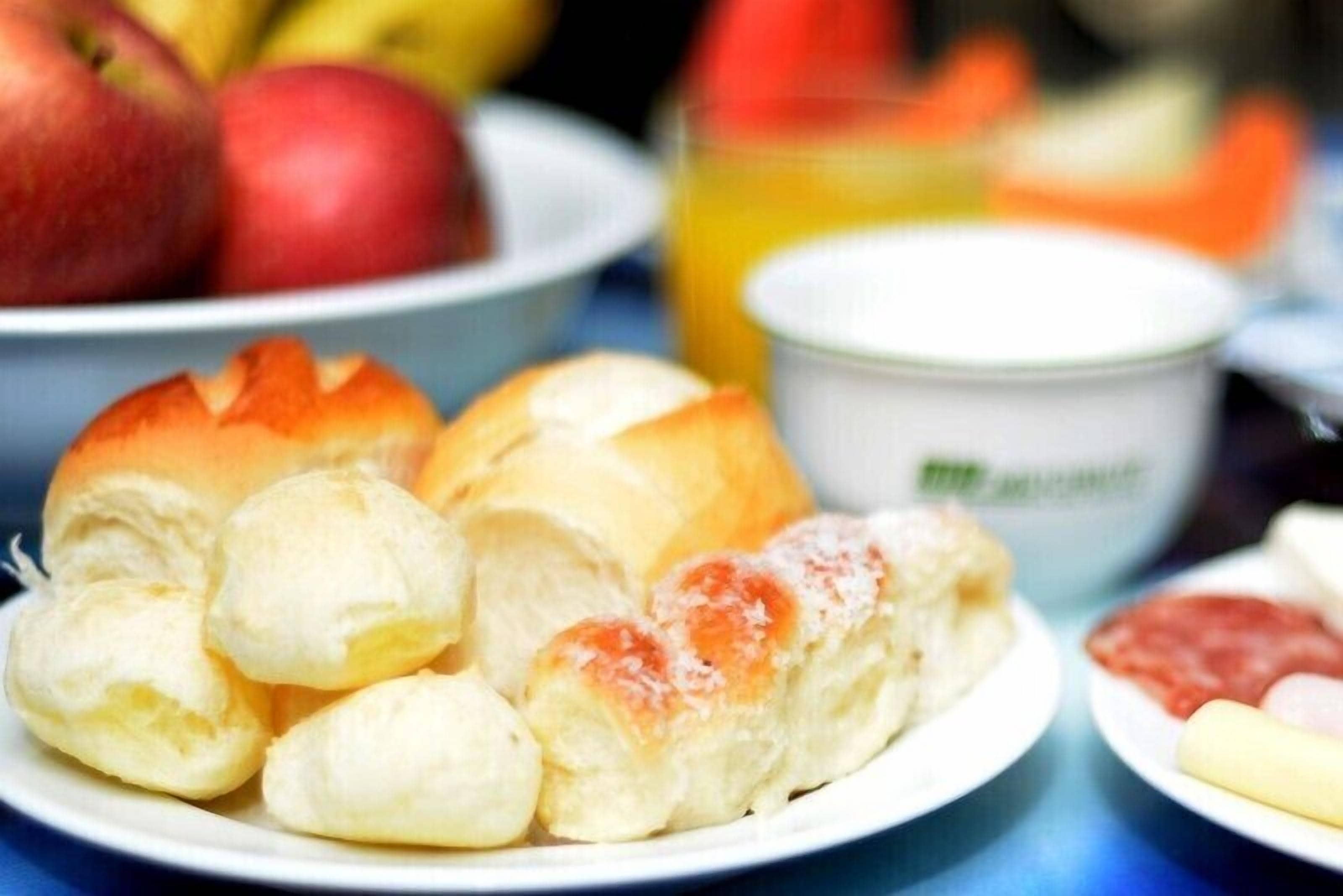 Un plato con bollos y un cuenco de manzanas.
