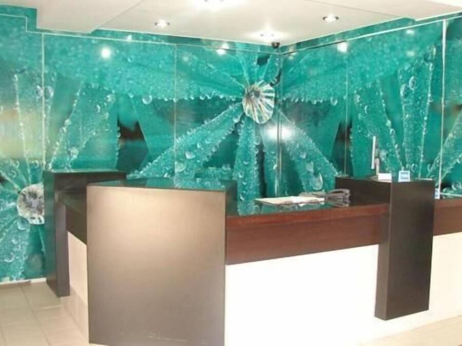 Una zona de recepción con pared de mármol y mostrador de madera.