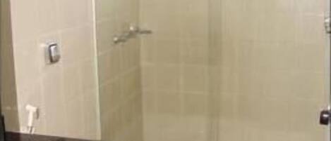 A bathroom with a toilet, a sink, and a glass-enclosed shower area.