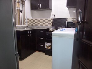 Een koelkast met diepvriezer, een microgolfoven, een oven, een kookplaat