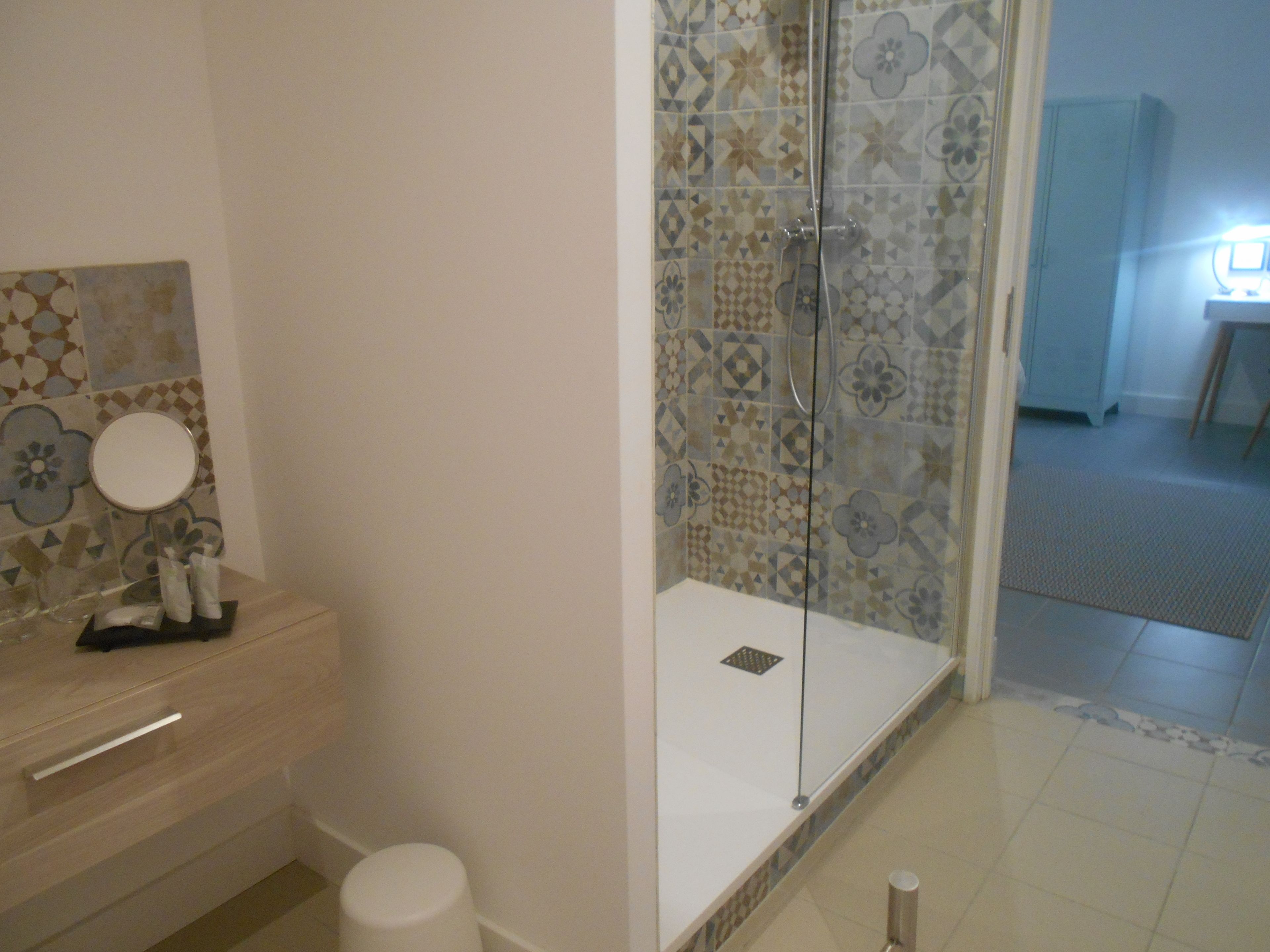 Un baño con ducha, inodoro y lavamanos con espejo.