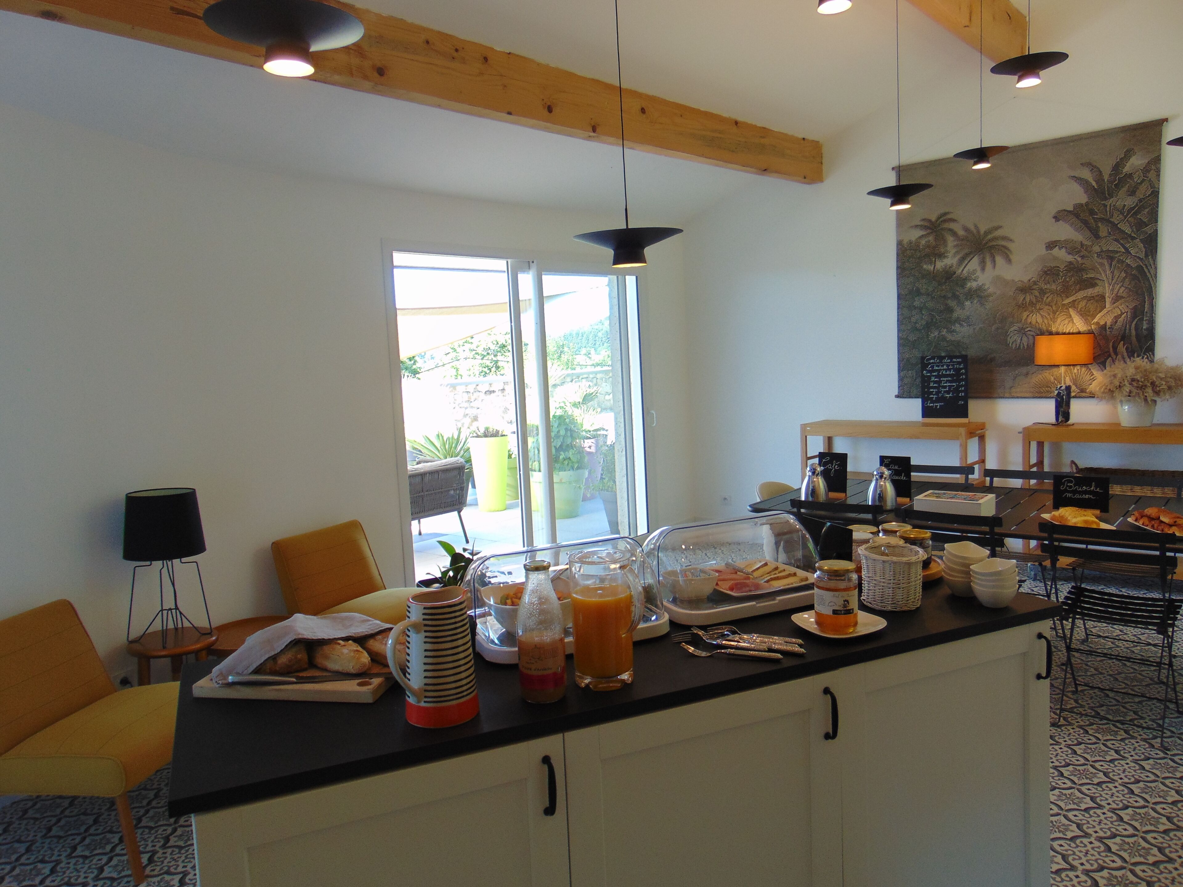 A breakfast bar with a clear glass display case, a coffee station, and a view of the outdoors.