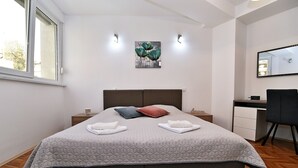 A bedroom with a bed, nightstands, a desk, and a chair. - Apartment Fran Green & Blue (Rijeka)