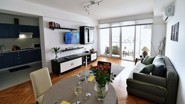 A modern living space with a kitchen, dining area, and a sofa. - Apartment Fran Green & Blue (Rijeka)