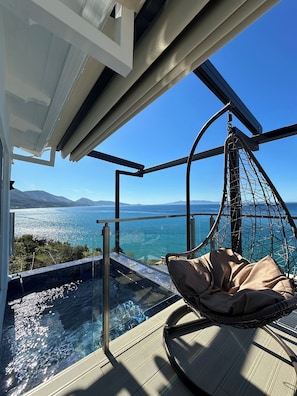 Relax in a serene outdoor seating area overlooking a tranquil body of water with a clear view of the surrounding landscape.