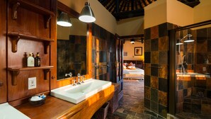 Un bagno con un mobile vanitario in legno, un ampio specchio e una zona doccia.