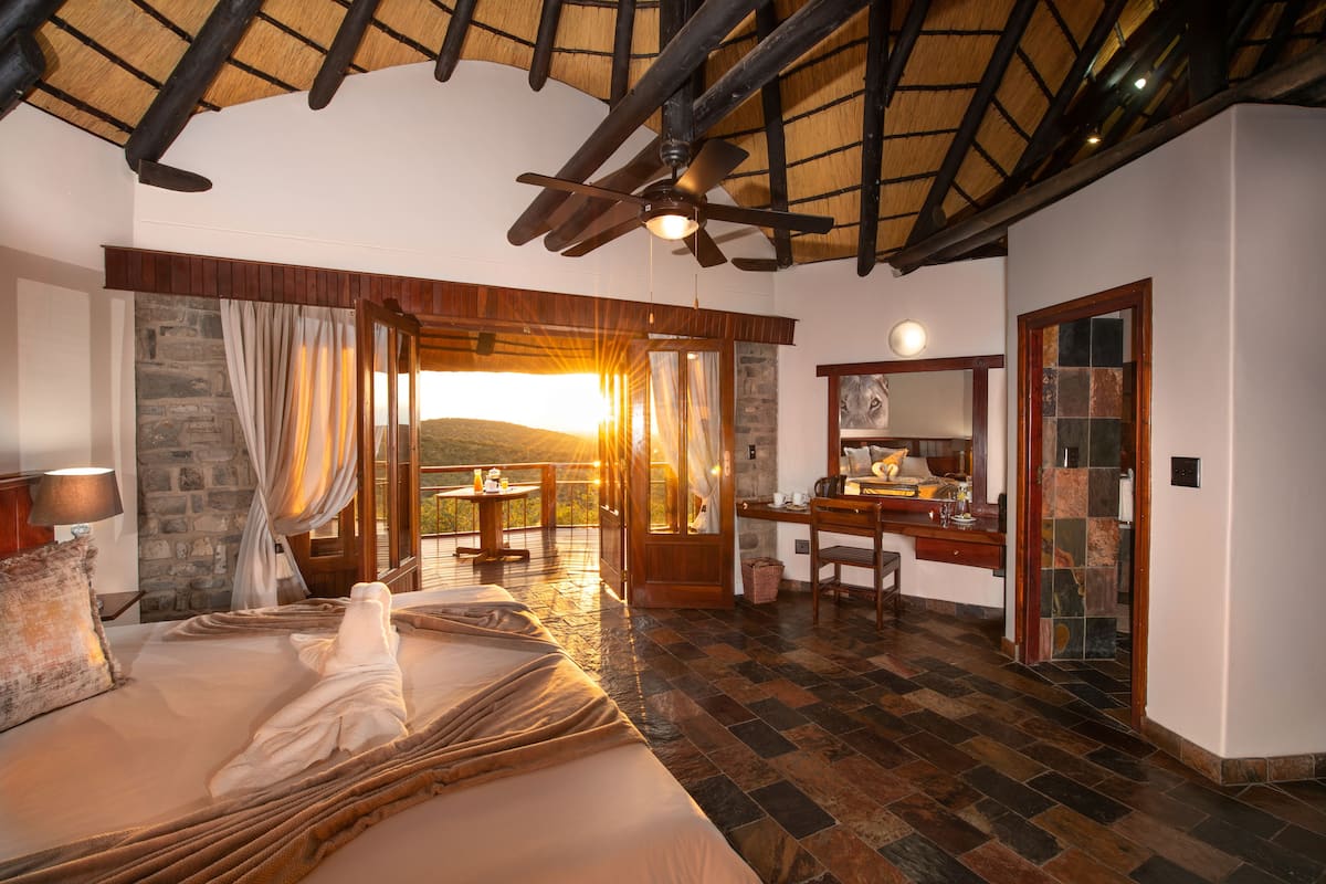 Une chambre spacieuse avec un grand lit, un bureau et une vue sur l’extérieur.