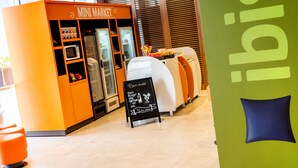 Een kleine winkel met een schoolbord, een koelkast en een magnetron.