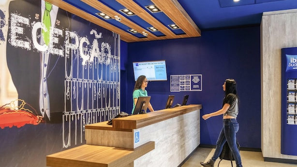 Een receptiebalie met een blauwe muur en een groot 'ECEPCA' bord.