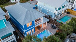 A two-story house with a blue exterior and a covered patio area. - Casa Azul - Adorable Home Close to the Beach with Private Pool & Patio! (Miramar Beach)