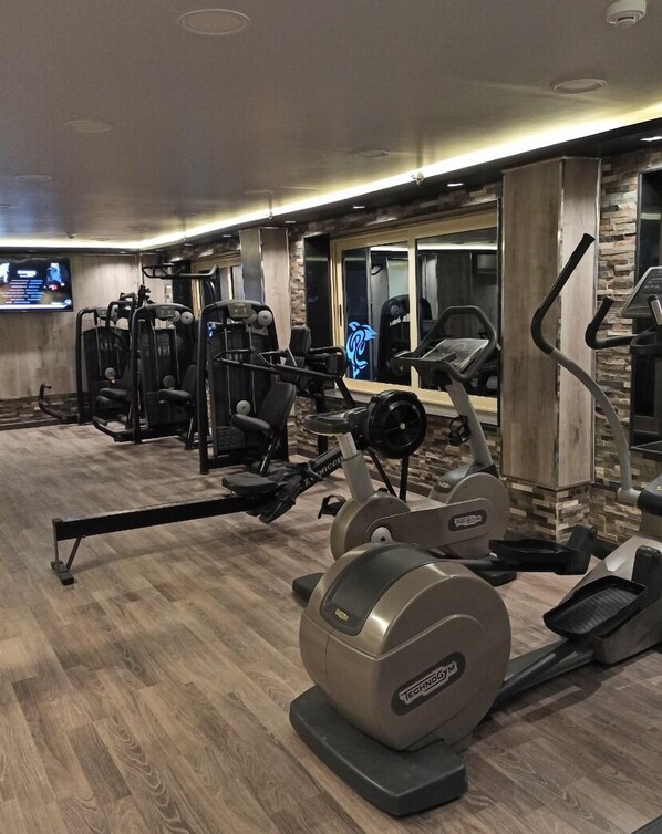 A gym with various exercise equipment, including treadmills and weight machines.
