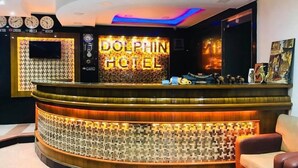 A reception desk with a 'Dolphin Hotel' sign, a wall clock, and a television. - Dolphin Ras Elbar (Damietta)