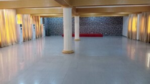 Un vaste hall doté d’un sol ciré, de grandes colonnes et d’un mur en pierre en arrière-plan.