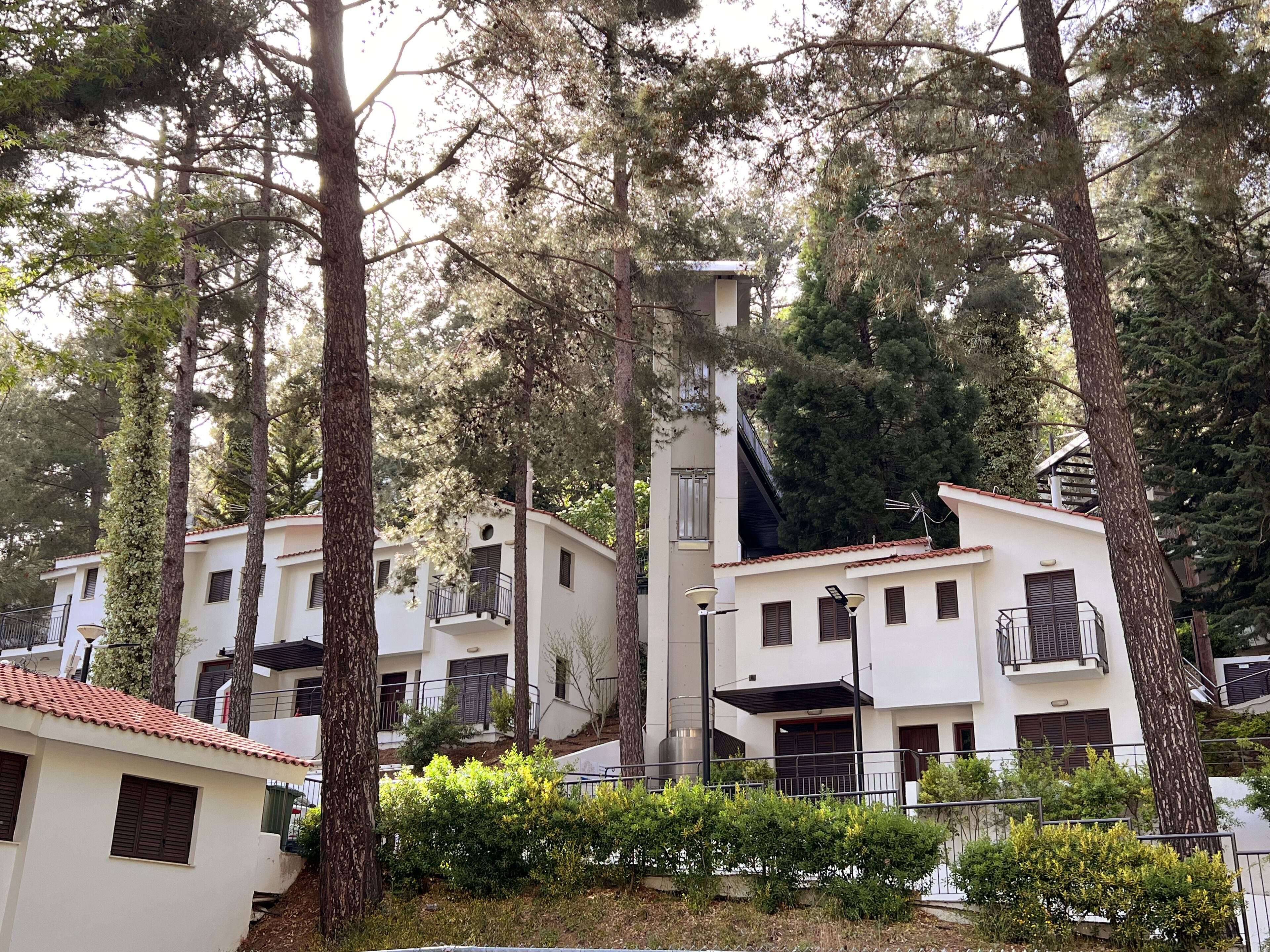 Una zona residencial con edificios blancos, balcones y árboles.