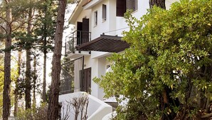 A multi-story building with balconies, surrounded by trees and greenery. - Poed Residences (Platres)