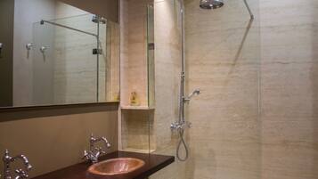A bathroom with two sinks, a glass shower enclosure, and a mirror.