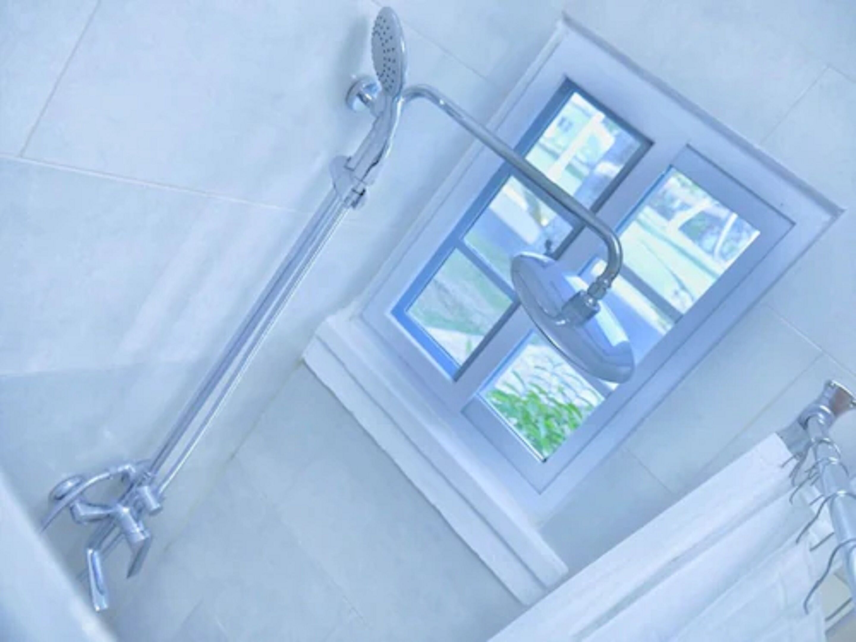 A bathroom with a shower, a window, and a view of the outside.
