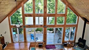 A spacious room with a high ceiling, large windows, and a wooden interior. - Stunning Cottage on a Very Private Lake (Kinmount)