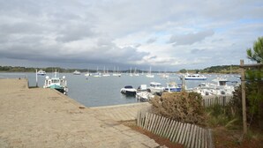 Un puerto deportivo con barcos amarrados, un camino de piedra y una valla de madera.