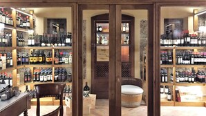 Una bodega con estantes de madera llenos de diversas botellas de vino.