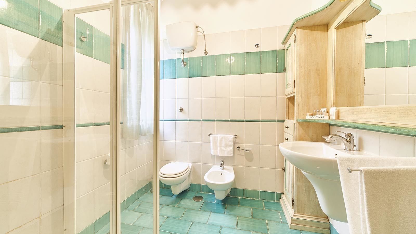Une salle de bain équipée de toilettes, d’un bidet et d’un lavabo.