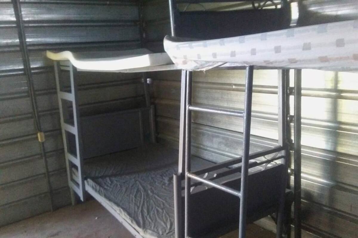 A bunk bed with metal railings and a mattress.