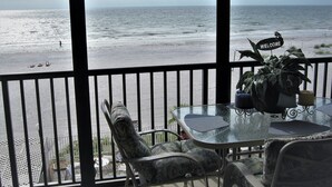 A balcony with a glass table, chairs, and a 'Welcome' sign. - Sand Castle III Luxury Condo, Free nights for select dates. (Indian Shores)