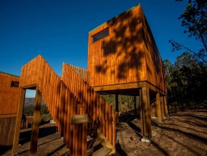 Una cabaña de madera con techo inclinado y una pequeña ventana.